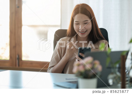 portrait of cheerful asian woman are happy while using smartphone for video call. business concept portrait of cheerful asian woman are happy while using smartphone for video call. business concept 85625877