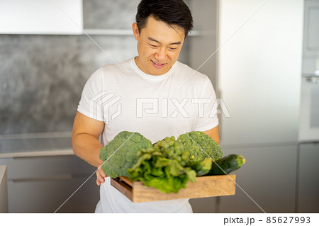 Man sniff fresh organic vegetables in wooden box Man sniff fresh organic vegetables in wooden box 85627993