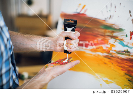 Talented man applying various paints on hand 85629907