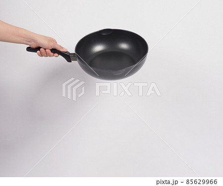 Cleaning Electric non stick pan. Hand on white background cleaning