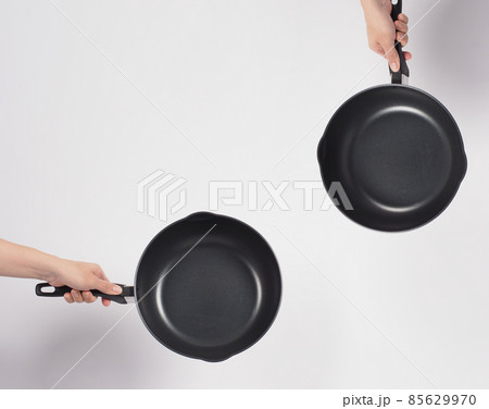 Cleaning Electric non stick pan. Hand on white background cleaning the non stick pan with handy dish washing sponge which yellow color on the soft side and green on hard side for hygiene after cook. Cleaning Electric non stick pan. Hand on white background cleaning the non stick pan with handy dish washing sponge which yellow color on the soft side and green on hard side for hygiene after cook. 85629970