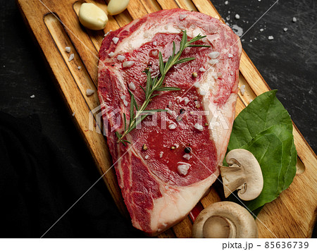 Top view of a raw steak with seasoning on a wooden board 85636739