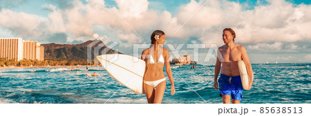 Hawaii Honolulu couple surfers happy on waikiki beach with surfboards. Healthy active sport lifestyle fitness people at sunset with diamond head mountain landscape Hawaii Honolulu couple surfers happy on waikiki beach with surfboards. Healthy active sport lifestyle fitness people at sunset with diamond head mountain landscape 85638513