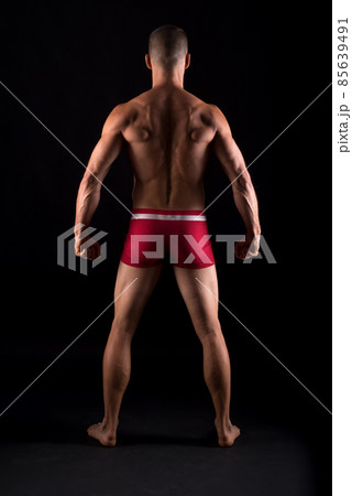 Studio photo of the back of strong man, black background 85639491