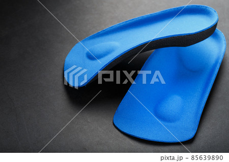 Orthopedic insoles for correction of pronation of the foot on a dark background. Orthopedic insoles for correction of pronation of the foot on a dark background. 85639890