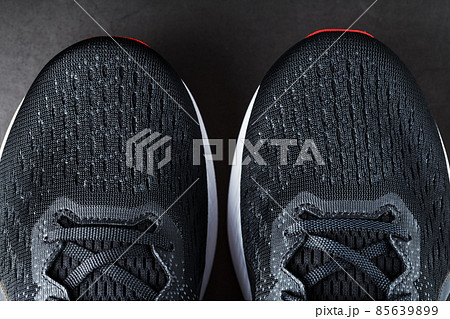Black running shoes with mesh and black laces close-up on a dark background Black running shoes with mesh and black laces close-up on a dark background 85639899