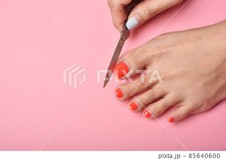 Woman feet on pink background, Red nail pedicure, Beauty salon concept. 85640600