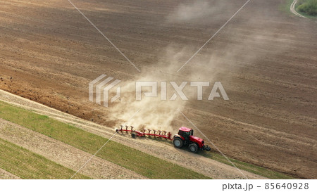 4K Aerial Flat View Tractor Plowing Field In Spring Season. Beginning Of Agricultural Spring Season. Cultivator Pulled By A Tractor In Countryside Rural Field Landscape. Birds In Flock Following For 4K Aerial Flat View Tractor Plowing Field In Spring Season. Beginning Of Agricultural Spring Season. Cultivator Pulled By A Tractor In Countryside Rural Field Landscape. Birds In Flock Following For 85640928