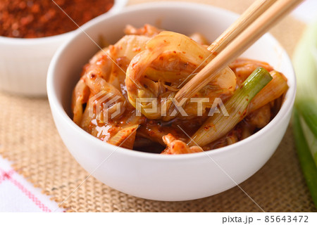 Kimchi cabbage in a bowl eating by use chopsticks, Korean homemade fermented side dish food 85643472