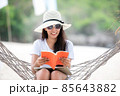 Lifestyle young woman using laptop working and reading book for relax on the beach 85643882