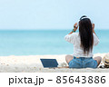 Lifestyle freelance woman listen music after using laptop working and relax on the beach. 85643886