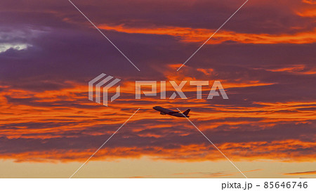 Plane in front of red glowing clouds in the evening red Plane in front of red glowing clouds in the evening red 85646746