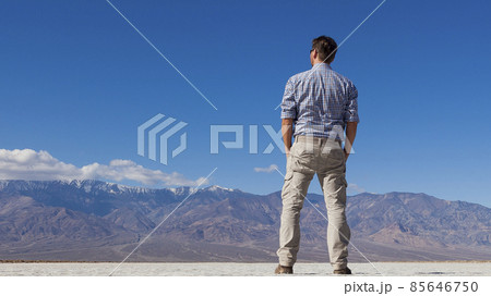 Man looks at distant mountain massif Man looks at distant mountain massif 85646750