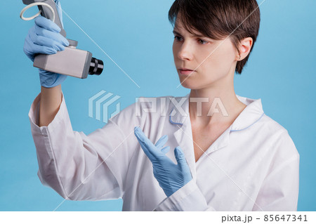 portrait of a young Caucasian female doctor looking at CCTV camera as an idea of monitoring doctors at work portrait of a young Caucasian female doctor looking at CCTV camera as an idea of monitoring doctors at work 85647341