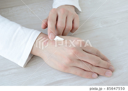 手荒れ・あかぎれの手にクリームを塗る女性の手元 85647550