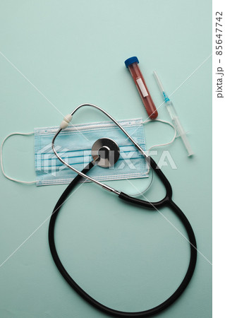 Top view stethoscope, test tube with blood samples and syringe isolated on blue background. Vertical image 85647742