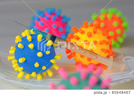新型コロナウイルスワクチン接種をコロナ菌模型と注射器でイメージした物撮り写真 85648407
