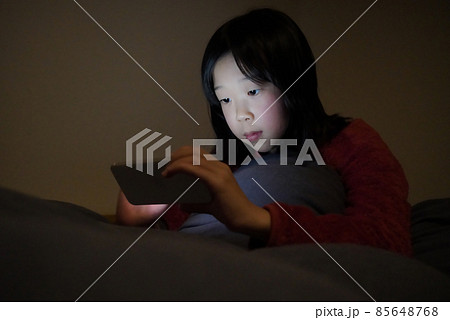 スマホで夜更かしする子ども 85648768