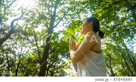 自然公園でヨガを行いリフレッシュする女性の写真素材