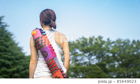 ヨガマットを持って練習に向かう女性 85649023