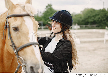 Portrait of riding horse with woman in black helmet 85649506