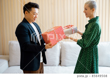 Asian man and young woman giving gifts each other 85649508