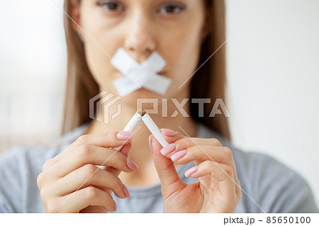 Young woman with broken cigarette, stop smoking concept. 85650100