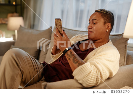 Woman using phone at home Woman using phone at home 85652270
