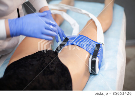 The procedure of myostimulation on the legs of a woman in a beauty salon. The procedure of myostimulation on the legs of a woman in a beauty salon. 85653426