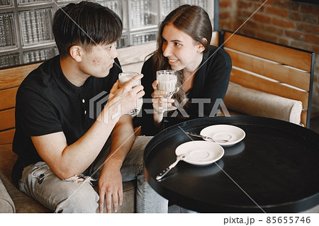 Young couple holding a cups of cappuccino in a restaurant Young couple holding a cups of cappuccino in a restaurant 85655746