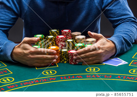 Poker player taking poker chips after winning Poker player taking poker chips after winning 85655751