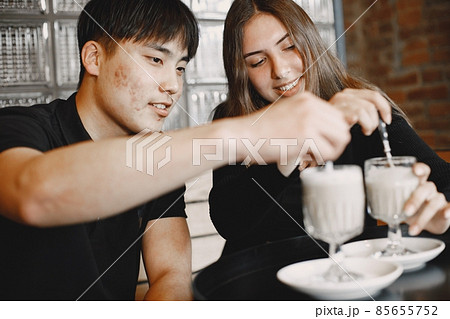 Young couple looking on a cups of cappuccino in a restaurant 85655752