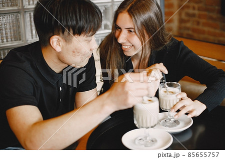 Young couple holding a cups of cappuccino in a restaurant 85655757