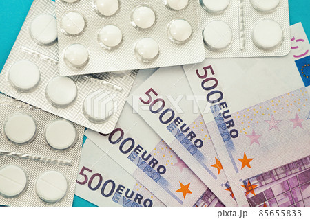 Money pills. Medicine pills on euro bills on a blue background. Covid-19 coronavirus pills are in Money pills. Medicine pills on euro bills on a blue background. Covid-19 coronavirus pills are in 85655833