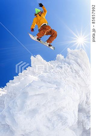 Snowboarder jumping against blue sky in high mountains 85657992