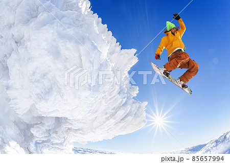 Snowboarder jumping against blue sky in high mountains 85657994