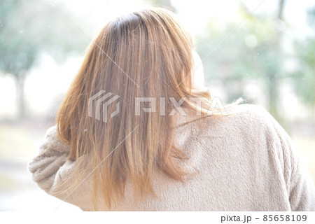 ゆきの降る中を黄色の傘をさして歩く女性 85658109