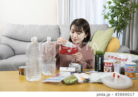 笑顔で非常用持出袋の中身を確認する女性 85660017