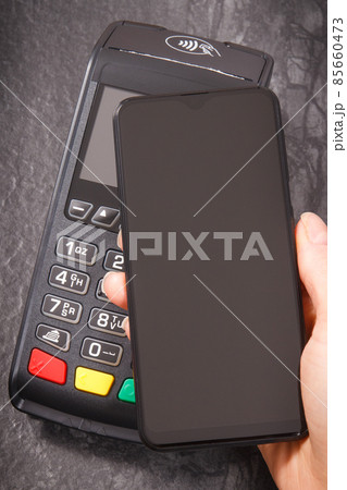 Hand of woman using payment terminal and smartphone to cashless paying. Finance concept Hand of woman using payment terminal and smartphone to cashless paying. Finance concept 85660473