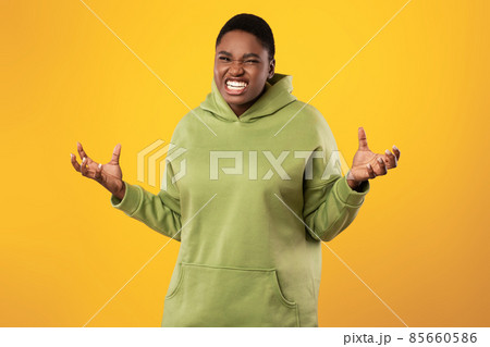 Angry Overweight Black Woman Clenching Teeth Posing Over Yellow Background Angry Overweight Black Woman Clenching Teeth Posing Over Yellow Background 85660586