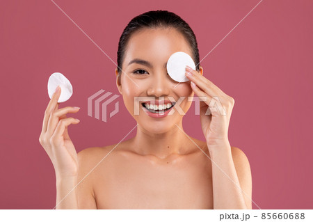 Cheerful japanese woman posing with cotton pads 85660688