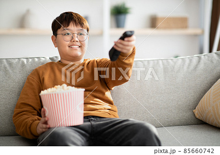 Relaxed chinese kid watching TV at home 85660742