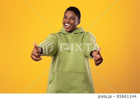 African American Female Gesturing Thumbs-Up With Both Hands, Yellow Background 85661144