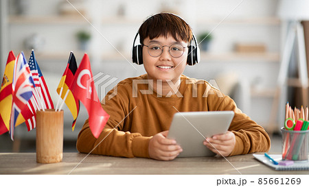 Positive chinese kid with wireless headset and digital tablet Positive chinese kid with wireless headset and digital tablet 85661269