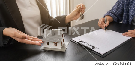 Real estate agent holding a key and asking costumer for contract to buy, get insurance or loan real estate or property. Real estate agent holding a key and asking costumer for contract to buy, get insurance or loan real estate or property. 85663332