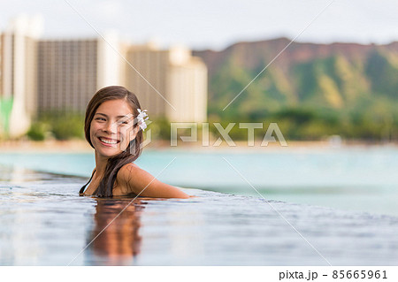 Hawaii luxury hotel vacation Asian woman relaxing in resort swimming pool overlooking Waikiki beach in Honolulu, Hawaii, USA Hawaii luxury hotel vacation Asian woman relaxing in resort swimming pool overlooking Waikiki beach in Honolulu, Hawaii, USA 85665961