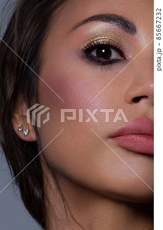 Half the face of a young sexy woman with pink lipstick on her lips and black eyeliner. Classic makeup and straight long hair. Evening make-up, cosmetology, spa, cosmetics, rejuvenation Half the face of a young sexy woman with pink lipstick on her lips and black eyeliner. Classic makeup and straight long hair. Evening make-up, cosmetology, spa, cosmetics, rejuvenation 85667232