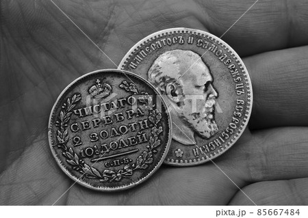 two old Russian silver coins of the 19th century in the palm, black and white image 85667484