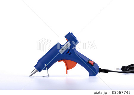 Side view of an electric hot glue gun on a white background. Side view of an electric hot glue gun on a white background. 85667745