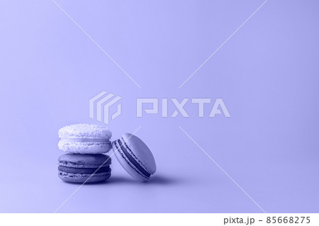 Three macaroons in stack toned in color of year 2022. Trendy background for your design. Food concept in vintage style. Copy space. Closeup. Three macaroons in stack toned in color of year 2022. Trendy background for your design. Food concept in vintage style. Copy space. Closeup. 85668275